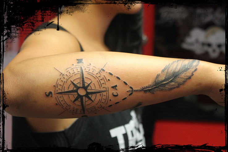 Kompass Tattoo mit einer Feder